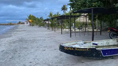 a boat sitting on a beach next to the ocean at Apartamento Atlantic 112 in La Perdiz