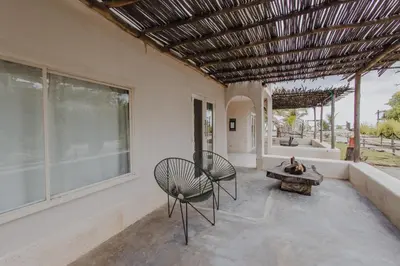 a patio with two chairs and a table and windows at Apartamento Atlantic 112 in La Perdiz