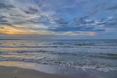 a beach with the ocean and a cloudy sky at Apartamento Atlantic 211 in La Perdiz
