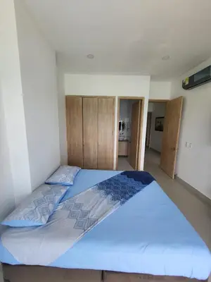a bedroom with a large bed with blue sheets at Apartamentos Mi Reserva OK - Bahía Marina in Coveñas