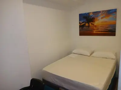 a bed in a room with a picture on the wall at Casa Marbella in Cartagena de Indias