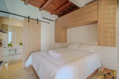 a bedroom with a white bed and a bathroom at CASA EMMA HOTEL Boutique in Cartagena de Indias