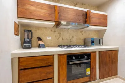 a kitchen with wooden cabinets and a stove top oven at Casa Fernandez By SoHo in Cartagena de Indias