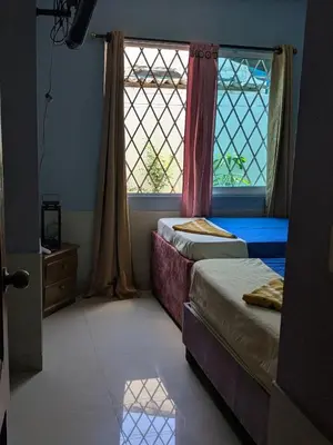 two beds in a room with two windows at Me Quedo Aqui, Casa Cerca del Aeropuerto de Cartagena! in Cartagena de Indias