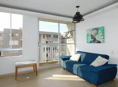 a living room with a blue couch and a window at Apartamento en alameda del Río Conjunto Azulejo in Barranquilla