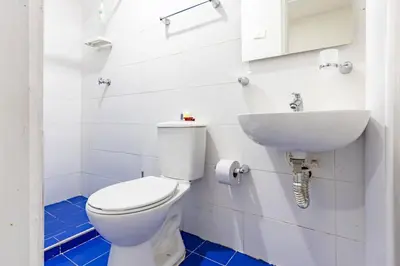 a bathroom with a white toilet and a sink at Luxury Bryon Pool in Cartagena de Indias