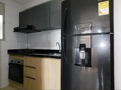 a kitchen with a black refrigerator and a stove at Apartamento en alameda del Río in Barranquilla