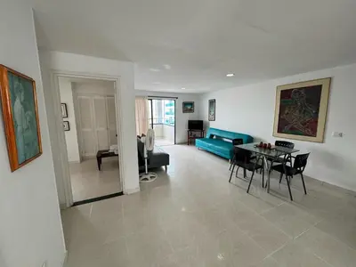 a living room with a blue couch and a table at Apartamentos En Edificio Portofino ICDI in Cartagena de Indias