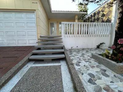 a house with a white garage door and stairs at El reposo real in Barranquilla
