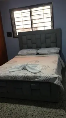 a bed with a large headboard and a window at El reposo real in Barranquilla
