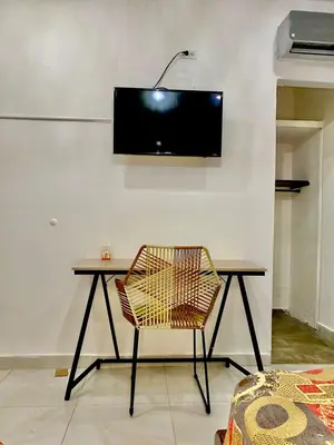 a desk with a chair and a television on a wall at Casa Centro Historico Hotel in Cartagena de Indias