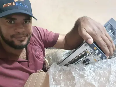 a man holding a laptop in a pile of plastic at mar azul in Cartagena de Indias