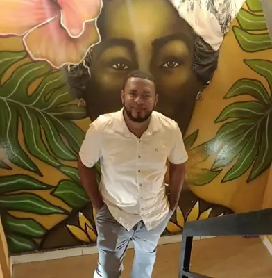 a man is standing in front of a mural at mar azul in Cartagena de Indias