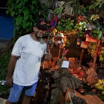 a man standing in front of a fruit stand at mar azul in Cartagena de Indias