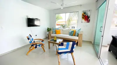 a living room with a couch and a table and chairs at Hermoso Apartamento Frente al Mar 2 Habitaciones B12A in Coveñas