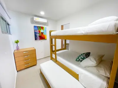 a bedroom with two bunk beds and a dresser at Hermoso Apartamento Frente al Mar 2 Habitaciones B12A in Coveñas