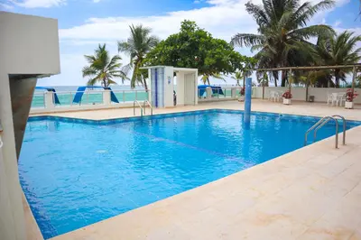 a large swimming pool with blue water and palm trees at Hermoso Apartamento Frente al Mar 2 Habitaciones B12A in Coveñas