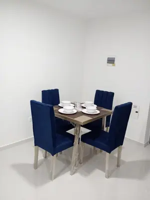 a wooden table with four blue chairs around it at Apartamento Manglar C Mallorquin Vista al Mar in Puerto Colombia