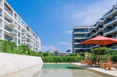 a pool with chairs and an umbrella and a building at Exclusive Loft In Cartagena By Huepedia in Cartagena de Indias