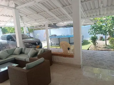 a covered patio with a couch and chairs and a grill at Casa Luna in Santa Veronica