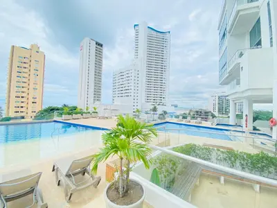 a balcony with a pool and chairs and buildings at Melodias de Verano in Cartagena de Indias