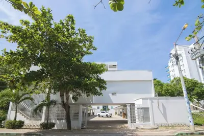 a white building with a tree in front of it at Hermoso Apartamento Frente al Mar 2 Habitaciones B12B in Coveñas