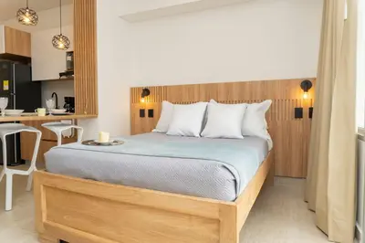 a bedroom with a bed with a wooden headboard at CB1004 Nueva Suite Frente al Mar - 2min Aeropuerto in Cartagena de Indias