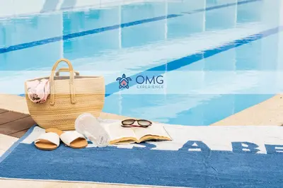 a towel with a book and a basket and sandals next to a pool at CB1004 Nueva Suite Frente al Mar - 2min Aeropuerto in Cartagena de Indias
