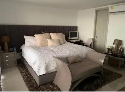 a bedroom with a bed and a desk and a chair at Yuyos apartamentos acogedores in Barranquilla