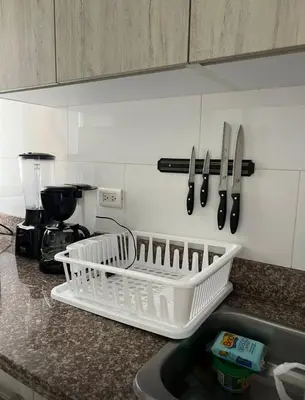 a kitchen counter with a white dish rack and knives at Yuyos apartamentos acogedores in Barranquilla