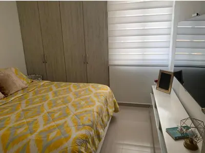 a bedroom with a bed and a desk with a laptop at Yuyos apartamentos acogedores in Barranquilla