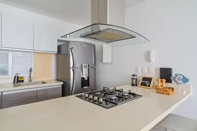 a kitchen with a stove top oven in a kitchen at Descanso y playa, cómodo apartamento en Kuali, Santa Marta in Santa Marta