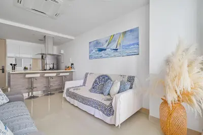 a living room with a couch and a kitchen at Descanso y playa, cómodo apartamento en Kuali, Santa Marta in Santa Marta