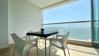 a table and chairs in a room with a large window at Apartamento de una habitacion Palmetto Sunset 1703 in Cartagena de Indias
