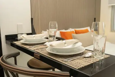 a dining table with plates and glasses on it at Acogedora suite frente al mar + vista CB1427 in Cartagena de Indias