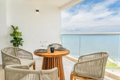 a table and chairs in a room with a view of the ocean at CB1526 | Suite tropical piso 15 frente al mar in Cartagena de Indias