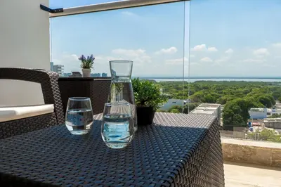 two glasses and a vase sitting on top of a table at CB937 | Stylish loft piso 9 con balcón y vista ciudad in Cartagena de Indias