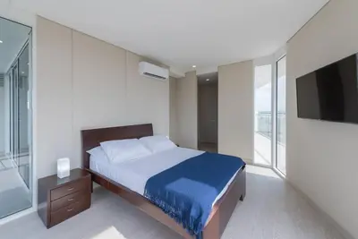 a bedroom with a bed and a flat screen tv at 2BD Next to Beach W Pvt Jacuzzi Martinique 74 in Cartagena de Indias