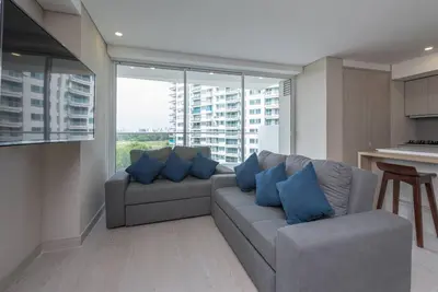 a living room with a gray couch and blue pillows at 2BD Next to Beach W Pvt Jacuzzi Martinique 74 in Cartagena de Indias