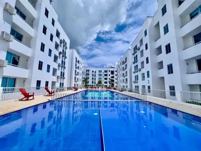 a swimming pool in the middle of two apartment buildings at Caribe campestre coveñas in Coveñas