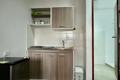 a small kitchen with wooden cabinets and a sink at Apartaestudios la terraza 2 in Sincelejo