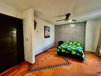 a living room with a bed and a brick wall at Apartaestudios la terraza 3 in Sincelejo