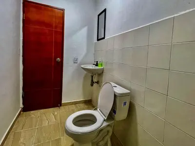 a bathroom with a toilet and a sink and a red door at Apartaestudios la terraza 3 in Sincelejo
