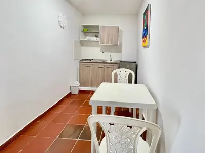 a small kitchen with a white table and chairs at Apartaestudios la terraza 3 in Sincelejo