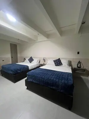 two beds with blue and white sheets in a room at Kiimala Villas y Hotel in Puerto Viejo