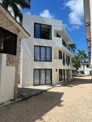 a white building with black windows on a street at Kiimala Villas y Hotel in Puerto Viejo