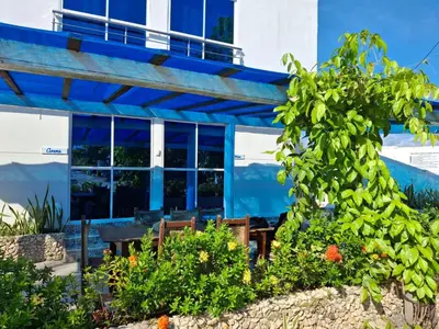 a blue building with a table and some plants at Cabañas Ana Sofía in San Antero