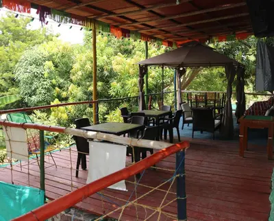 a deck with tables and chairs and a gazebo at Restaurante y Ecohostal Casa Loma in Chorrera