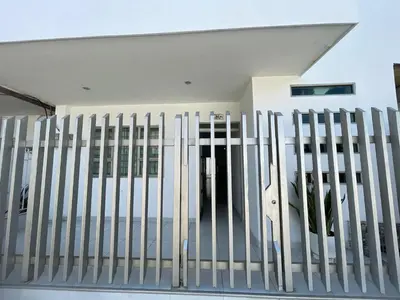 a white fence in front of a house at Apartamentos Mila in Guayabal