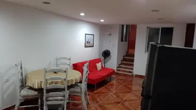 a living room with a table and a red couch at Apartamento Familiar para 6 personas in Cartagena de Indias